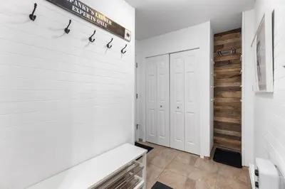 a bathroom with white walls and a white bench at 1BR and Sofabed in The Gables, Epic Village Location, Secure Parking, Forest Views in Whistler