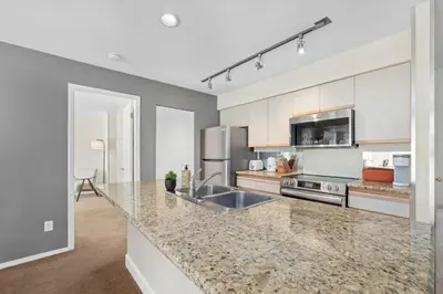 a kitchen with a sink and a counter top at 2BR in Ironwood, Stunning Mountain Views, Shared Hot Tub and Pool, Fireplace, Parking in Whistler