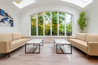 a living room with two couches and two tables at Serene 5-Bedroom Nature Retreat in West Vancouver