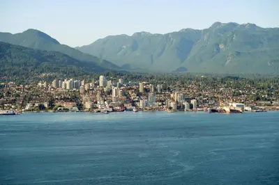 a city on the shore of a large body of water at Spacious 1BR Suite Near Capilano Bridge & Trails in North Vancouver
