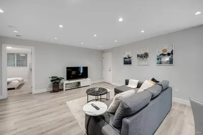 a living room with a couch and a tv at Spacious 1BR Suite Near Capilano Bridge & Trails in North Vancouver