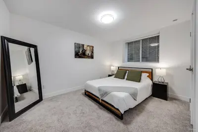 a white bedroom with a bed and a mirror at Modern 2Bed Suite Near Capilano Bridge & Trails in North Vancouver