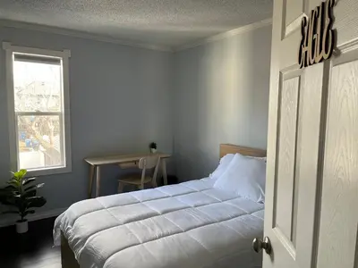 a bedroom with a bed and a window and a table at Character Home near Downtown and 17th Avenue in Calgary