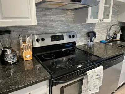 a kitchen with a stove and a counter top at Character Home near Downtown and 17th Avenue in Calgary
