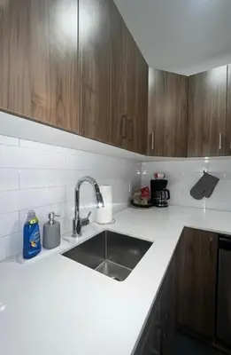 a kitchen counter with a sink and wooden cabinets at Apartment in Downtown YEG in Edmonton