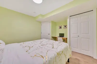 a bedroom with a white bed and a desk at Spacious 3 BDR Suite Sleeps 6 Comfortably in Edmonton