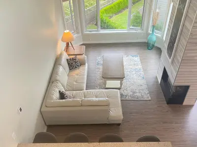 a living room with a white couch and a fireplace at Tanglewood 13 in Parksville
