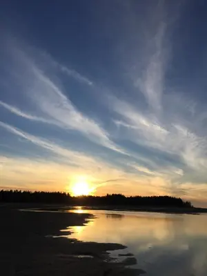 a sunset over a body of water with the sun setting at Tanglewood 18 in Parksville