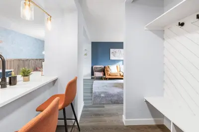 a living room with white walls and orange chairs at WEM Retreat | 3BR | Mins from the Mall in Edmonton