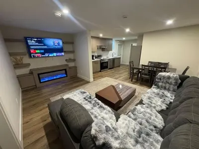 a living room with a couch and a flat screen tv at Peaceful 2BR Getaway with Fireplace & Parking Basement Suite in Abbotsford