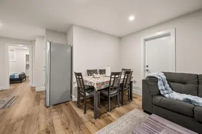 a dining room with a table and chairs and a couch at Peaceful 2BR Getaway with Fireplace & Parking Basement Suite in Abbotsford