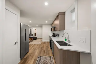 a kitchen with white counter tops and wooden cabinets at Peaceful 2BR Getaway with Fireplace & Parking Basement Suite in Abbotsford
