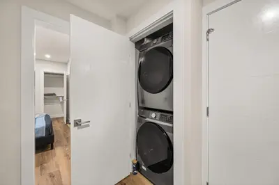 a laundry room with two washer and dryer at Peaceful 2BR Getaway with Fireplace & Parking Basement Suite in Abbotsford