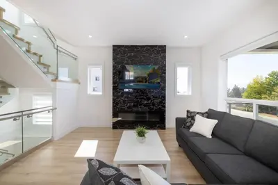 a living room with a couch and a fireplace at Spacious 6BR Home with Terrace Views and Parking nearby parks golf and resorts in Chilliwack