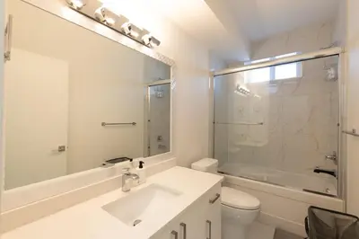 a white bathroom with a sink and a shower at Spacious 6BR Home with Terrace Views and Parking nearby parks golf and resorts in Chilliwack