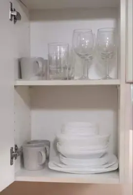 a cabinet filled with glasses and plates and dishes at Stylish Home in Van West Side Near YVR&DT in Vancouver