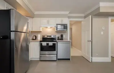 a kitchen with a stainless steel stove and refrigerator at Stylish Home in Van West Side Near YVR&DT in Vancouver