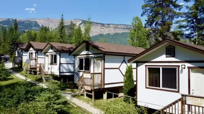 a row of cottages with mountains in the background at Mountain View Cabins in Golden