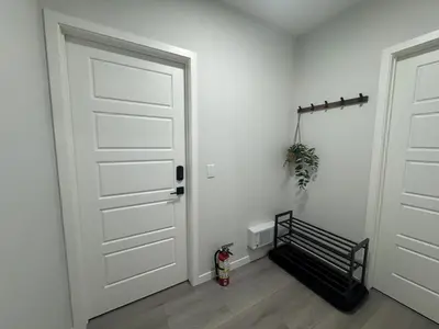 a white door with a bench in a room at Rockies Golden Retreat 2BR Suite at Glacier Ridge NW Calgary in Calgary