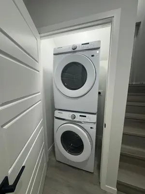 a washer and dryer in a small room at Rockies Golden Retreat 2BR Suite at Glacier Ridge NW Calgary in Calgary