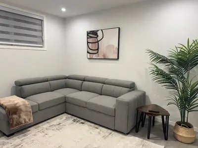 a living room with a couch and a plant at Rockies Golden Retreat 2BR Suite at Glacier Ridge NW Calgary in Calgary