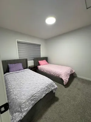 a bedroom with two beds and a window at Family Friendly Rockies Retreat at Glacier Ridge NW Calgary in Calgary