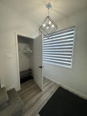 a room with a door with a window and a chandelier at Family Friendly Rockies Retreat at Glacier Ridge NW Calgary in Calgary