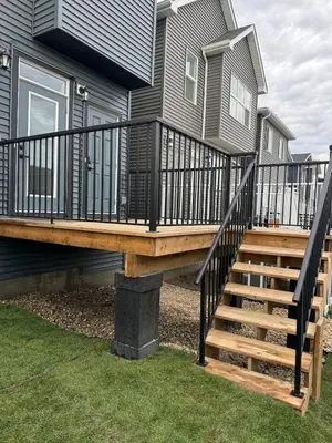 a deck with a staircase leading up to a house at Family Friendly Rockies Retreat at Glacier Ridge NW Calgary in Calgary