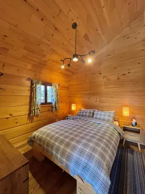 a bedroom with a bed in a log cabin at Radium Cabins Centrally located in Radium Hot Springs BC in Radium Hot Springs