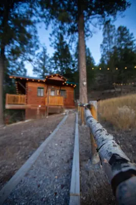 a log cabin in the woods next to a pipe at Radium Cabins Centrally located in Radium Hot Springs BC in Radium Hot Springs