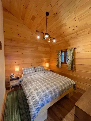 a bedroom with a bed in a log cabin at Radium Cabins Centrally located in Radium Hot Springs BC in Radium Hot Springs