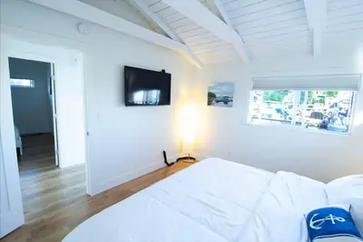 a white living room with a white couch and a tv at Cozy modern floating home next to Lonsdale Quay in North Vancouver
