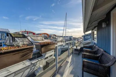 a balcony with two boats and a table and chairs at Cozy modern floating home next to Lonsdale Quay in North Vancouver