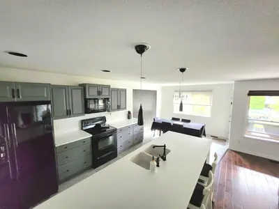 a kitchen with a white counter top and a kitchen island at Kelowna full level luxury-BIG white ski 35 mins in Kelowna