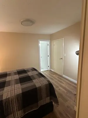 a bedroom with a bed with a plaid blanket at Cozy Ground-Floor Room with Private Bath and Separate Entry in Delta