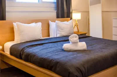 a bedroom with a large bed with a towel on it at Elkview by Fernie Central Reservations in Fernie