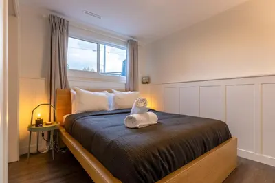 a bedroom with a large bed with a window at Elkview by Fernie Central Reservations in Fernie