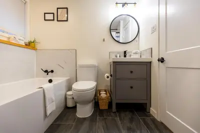 a bathroom with a tub and a toilet and a sink at Elkview by Fernie Central Reservations in Fernie