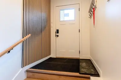 a hallway with a white door and a black rug at Elkview by Fernie Central Reservations in Fernie