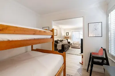 a bedroom with two bunk beds and a living room at Ski-In/Out | Upper Village | Free Parking in Whistler