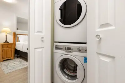 a washer and dryer in a room with a bedroom at Ski-In/Out | Upper Village | Free Parking in Whistler