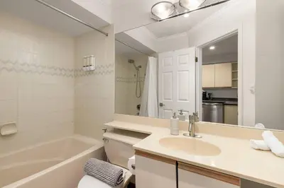 a white bathroom with a sink and a bath tub at Ski-In/Out | Upper Village | Free Parking in Whistler
