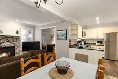 a kitchen and living room with a table and a couch at Ski-In/Out | Upper Village | Free Parking in Whistler