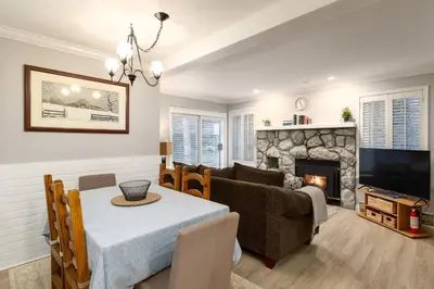 a living room with a table and a couch and a fireplace at Ski-In/Out | Upper Village | Free Parking in Whistler