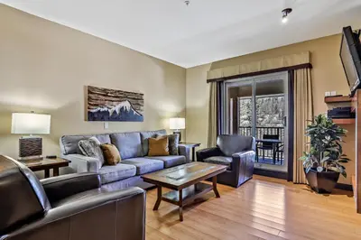 a living room with a couch and a table at Fantastic Mountain View - Hot Tubs & Steam Room in Canmore