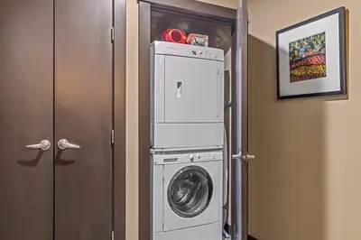 a washer and dryer in a room next to a door at Stunning Condo - Hot Tubs & Steam Room - Pets Ok in Canmore