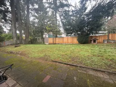 a backyard with a fence and a yard withgrass at The Sunshine Haven in Delta