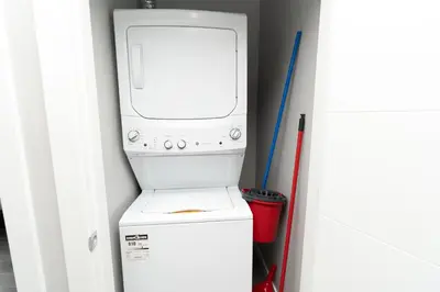a washer and dryer sitting on top of a refrigerator at Corporate Stays Village on 105 1 Bedroom in Edmonton