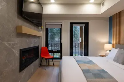 a bedroom with a bed and a fireplace and a tv at Brand New Canmore Studio - Cozy Mountain Getaway in Canmore