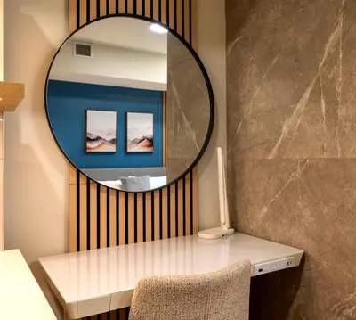 a mirror on a wall next to a desk with a chair at Brand New Canmore Studio - Cozy Mountain Getaway in Canmore
